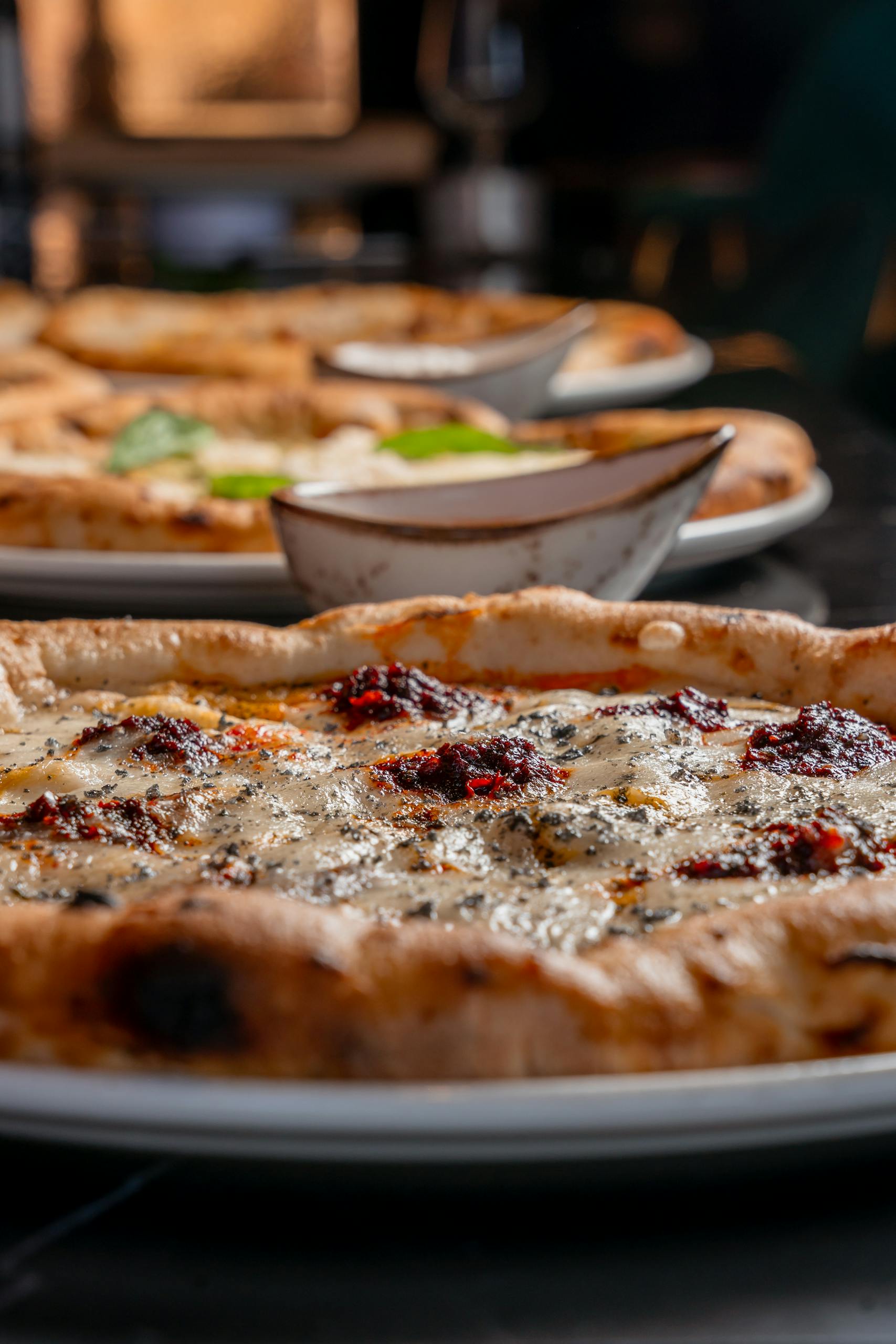 Fincsi pizza 1 Delicious artisanal pizza with deep flavors and vibrant toppings on a rustic plate.