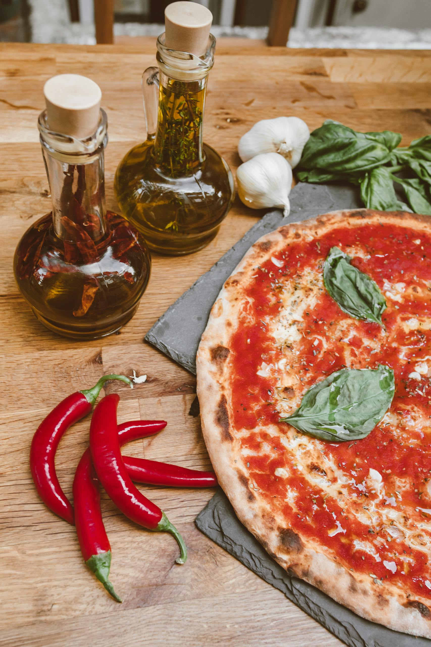 Csípősragus pizza 1 Delicious Italian pizza with fresh basil and olive oil on a wooden table.